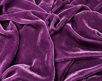 May include: Close-up of a deep purple velvet fabric with soft, flowing folds and a luxurious texture.