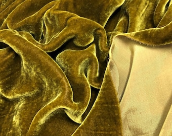 May include: Close-up of a rich, golden yellow velvet fabric with a soft, plush texture. The fabric is draped and folded, showcasing its luxurious feel.