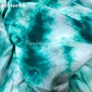 May include: A close-up of a fabric with a tie-dye pattern in shades of teal and white. The text "#color04" is in the upper left corner. The text "HandmadesilkGifts" is in the lower right corner.