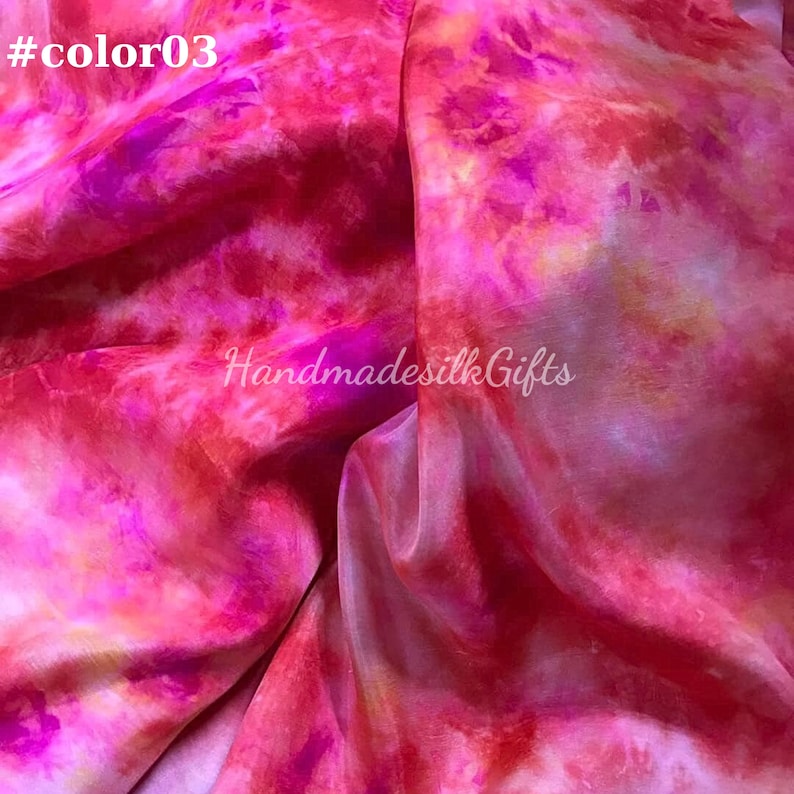 May include: A close-up of a silk fabric with a vibrant tie-dye pattern in shades of pink, red, and orange. The text "#color03" is in the top left corner, and "Handmadesilk Gifts" is in the center.