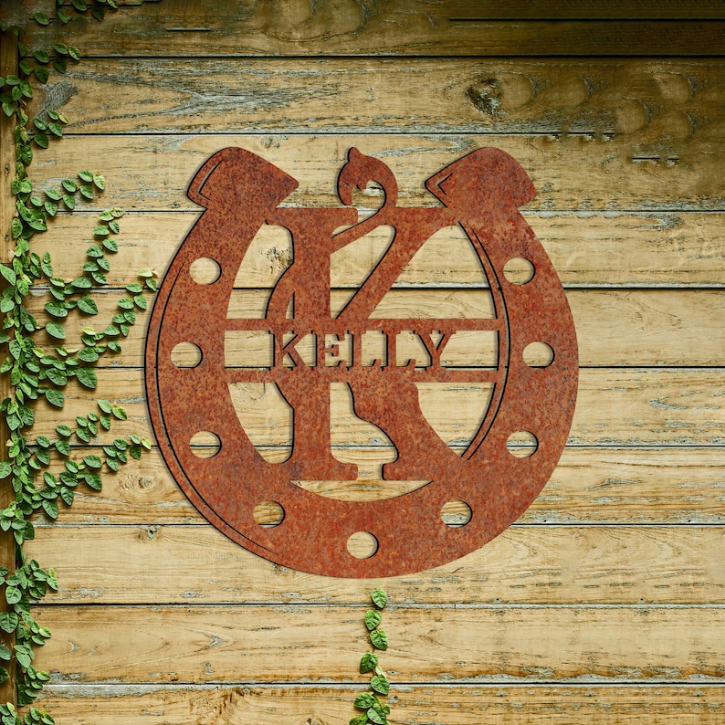 May include: A rusty metal horseshoe with the letter K in the center and the name Kelly written across the horseshoe.