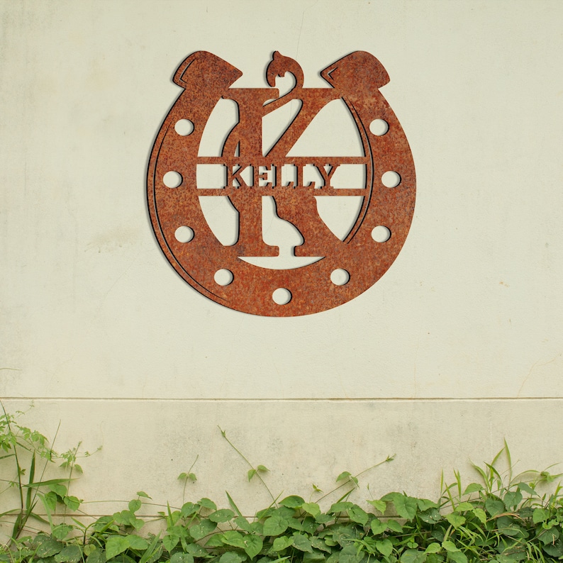 May include: A rusty metal horseshoe with the letter K in the center and the name "Kenny" written across the horseshoe.