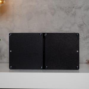 May include: A pair of black metal bookends with a simple, modern design. The bookends are made of a sturdy metal and have a smooth, matte finish.