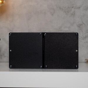 May include: A pair of black metal bookends with a simple, modern design. The bookends are made of a sturdy metal and have a smooth, matte finish.