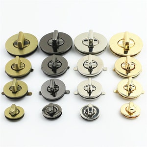 Puede incluir: Surtido de cierres redondos de metal en acabados dorado, plateado y negro. Los cierres tienen un cierre giratorio y están diseñados para su uso en bolsos, carteras y otros artículos de cuero.