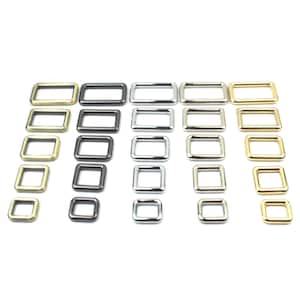 Könnte beinhalten: Sortiment aus Metall-D-Ringen in Gold-, Silber- und Schwarz-Finish. Die Ringe sind nach Größe und Farbe in Reihen angeordnet.