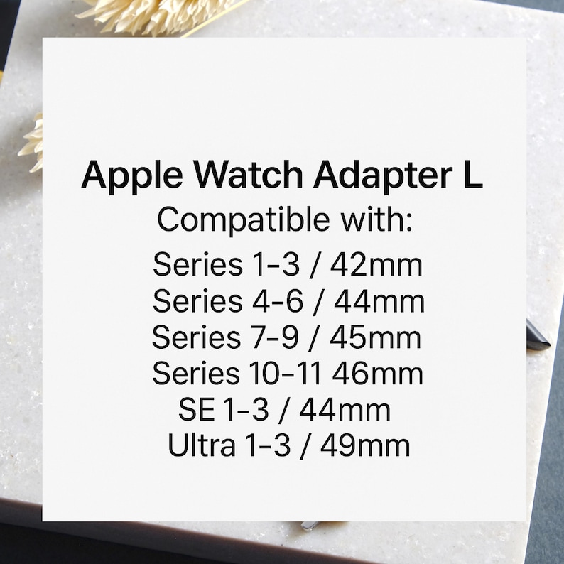 May include: White square with black text: "Apple Watch Adapter L". Compatible with Series 1-3 (42mm), Series 4-6 (44mm), Series 7-9 (45mm), Series 10-11 (46mm), SE 1-3 (44mm), and Ultra 1-3 (49mm).