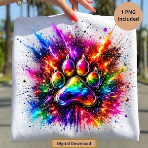 Puede incluir: Sudadera blanca con un diseño de huella de pata de arcoíris. La huella está rodeada de salpicaduras de pintura coloridas. También se ve el texto "1 PNG Included" y "Digital Download".