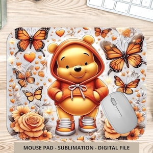 Puede incluir: Una alfombrilla de ratón con un oso de dibujos animados con una sudadera con capucha naranja, rodeado de mariposas, corazones y flores naranjas. La alfombrilla tiene un fondo blanco e incluye un ratón de ordenador. El texto "MOUSE PAD - SUBLIMATION - DIGITAL FILE" está en la parte inferior.