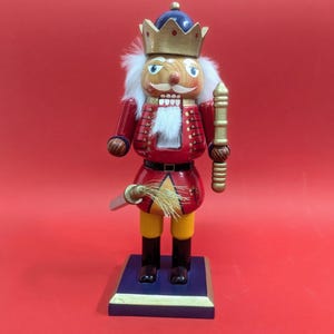 12&quot; Tall King Nutcracker Christmas Decoration in Red, Blue, and Gold with Blue Eyes.