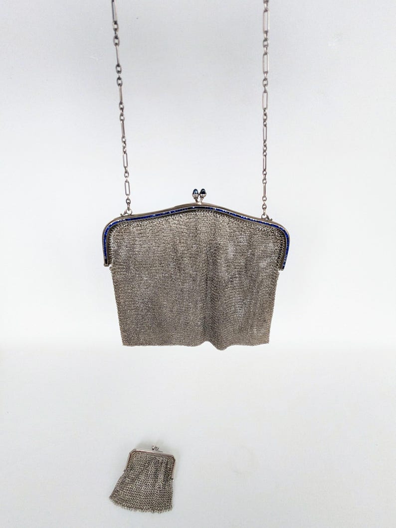 May include: A silver chain bag with a blue trim and a matching smaller bag. The bag is made of a fine mesh material.