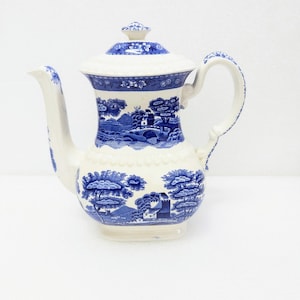 Könnte beinhalten: Eine weiße Teekanne aus Keramik mit einem blauen und weißen Blumenmuster. Die Teekanne hat einen Deckel und einen Griff. Die Teekanne ist mit einem blauen und weißen Blumenmuster verziert.