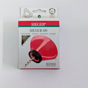 Pode incluir: Um saca-rolhas vermelho e preto na embalagem original. A embalagem é branca com detalhes vermelhos e verdes e apresenta a marca "SIEGER" e o modelo "600". A embalagem também inclui as palavras "saca-rolhas" e "cavatappi".