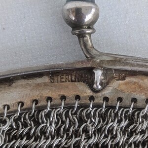 May include: A silver mesh purse with a sterling silver clasp and a blue stone top.