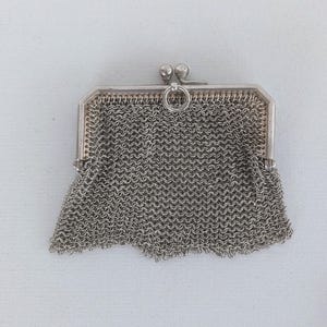 May include: A silver mesh coin purse with a clasp and a ring for a chain.