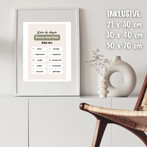 May include: A framed print with a light pink background and green text that reads "Wenn du diegen Raum betrittst bist du". The print has a list of words in white circles with small hearts in front of each word. The words are "wichtig", "bequem", "respektvoll", "mutig", "wunderbar", "muhlos", "vertrauensvoll", "verwirrt", "geborgen". The print is framed in a white frame and is hanging on a white wall. The text "INKLUSIVE: 21 x 30 cm 30 x 40 cm 50 x 70 cm" is written in white on a white background.