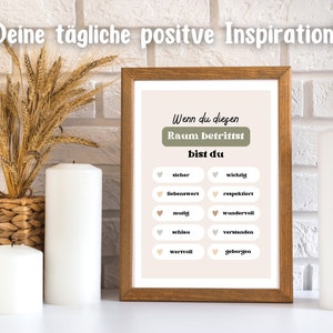 May include: A framed print with a beige background and the text "Wenn du diesen Raum betrittst bist du" in black. The print features a list of positive affirmations in German, including "sicher", "wichtig", "liebenswert", "respektiert", "mutig", "wundervoll", "schlau", "verstanden", "wertvoll", and "geborgen".