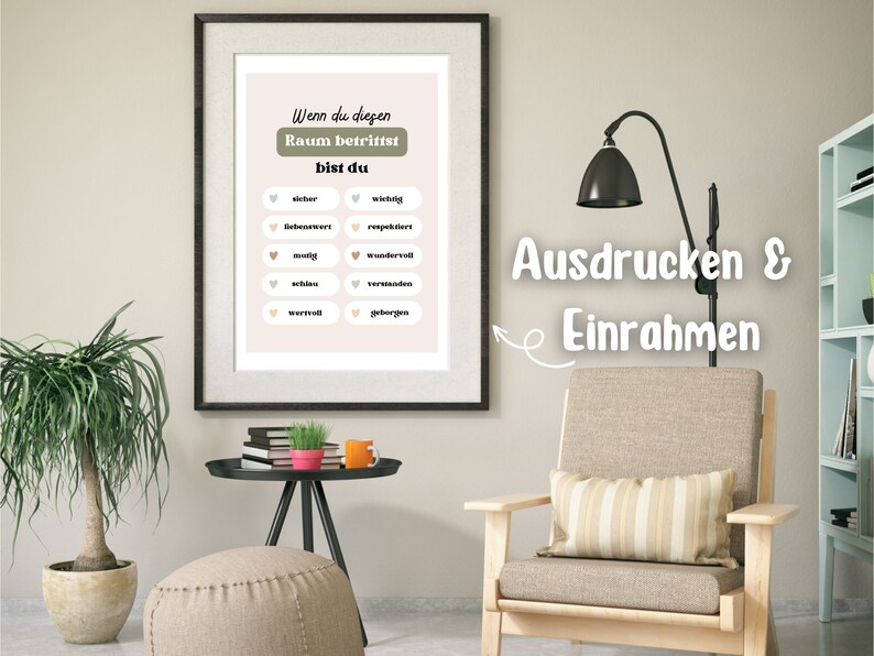 May include: A printable wall art poster with a light pink background and green and white text. The text reads "Wenn du diesen Raum betrittst bist du" and lists a series of positive adjectives in German. The poster is framed and hanging on a wall in a living room setting.