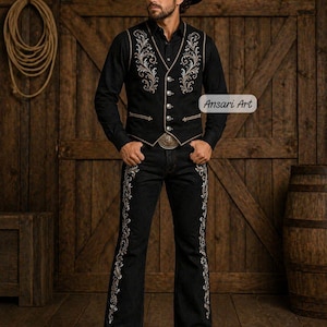 May include: A black cowboy outfit featuring an embroidered vest, shirt, and pants. The vest and pants have ornate silver and gold floral designs. The outfit includes a black cowboy hat and a belt with a decorative buckle. The text "Ansari Art" is visible.