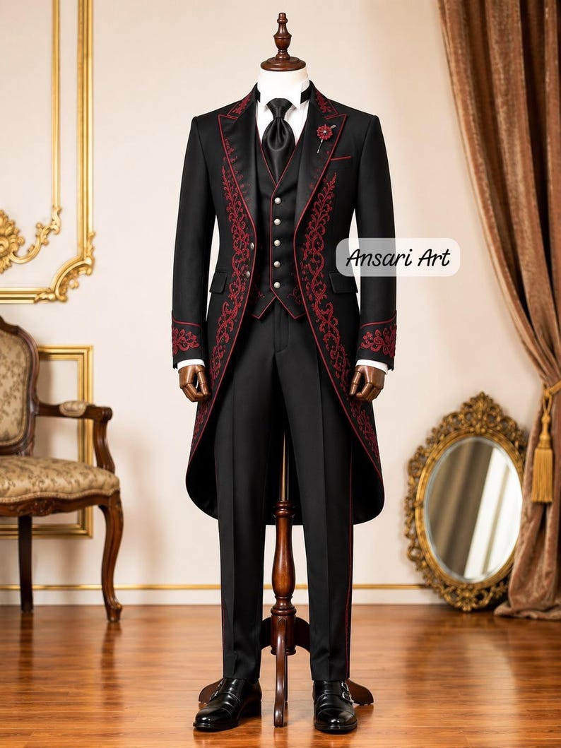 May include: A black tailcoat suit featuring intricate red embroidery along the lapels and cuffs, paired with a matching waistcoat with silver buttons, a white shirt, a black tie, and black trousers. The text Ansari Art is visible on the right side.