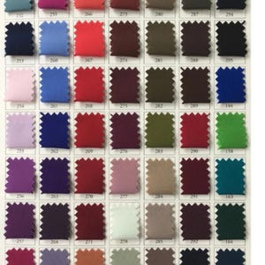 May include: A color chart featuring a variety of fabric swatches in an array of colors. The swatches are arranged in rows and columns, with each swatch labeled with a number. Colors include shades of blue, red, green, purple, and neutral tones.
