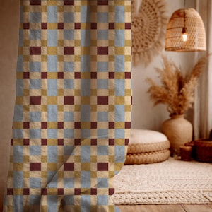 May include: A curtain featuring a repeating grid pattern of light blue, mustard yellow, and dark maroon squares. The fabric has a visible woven texture, creating a structured geometric design that covers the entire surface of the hanging panel.