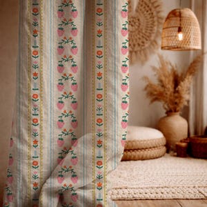 May include: Cream-colored fabric with vertical stripes and a repeating pattern of pink strawberries and orange flowers. The design includes blue and yellow accents, creating a vintage, floral aesthetic. This fabric is suitable for home decor.