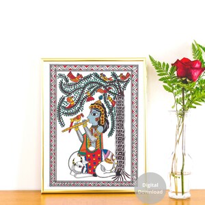May include: A colorful Madhubani painting depicting a blue-skinned figure playing a flute while sitting on a white cow. The figure is surrounded by a green tree with red and orange birds. The painting is framed in gold.
