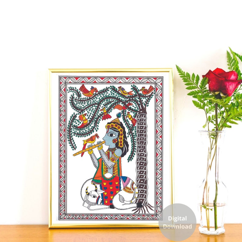 May include: A colorful Madhubani painting depicting a blue-skinned figure playing a flute while sitting on a white cow. The figure is surrounded by a green tree with red and orange birds. The painting is framed in gold.