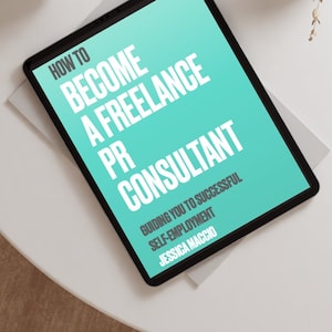 Può includere: Un tablet mostra il testo "HOW TO BECOME A FREELANCE PR CONSULTANT" su sfondo turchese. Sono visibili anche il testo "GUIDING YOU TO SUCCESSFUL SELF-EMPLOYMENT" e il nome dell'autore, Jessica Macchio. Nell'immagine sono presenti anche delle cuffie bianche e un vaso con piante secche.