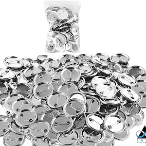 May include: A large pile of silver-colored metal button blanks. The blanks are round and have a pin back. The blanks are in a clear plastic bag.