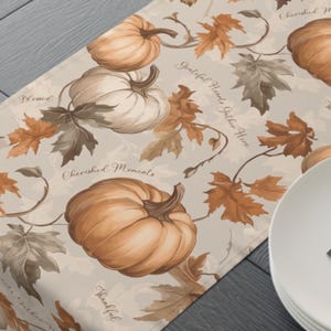 Puede incluir: Un camino de mesa beige con temática otoñal con calabazas, hojas y el texto "Cherished Moments", "Grateful Hearts Gather Here", "Blessed", "Thankful" y "Cherished Moments".