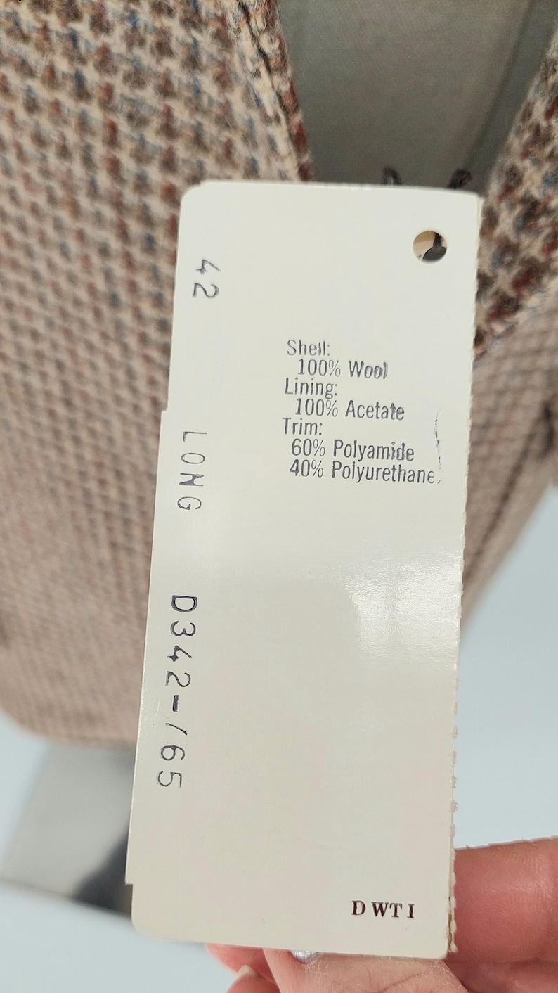 Peut inclure: Une &eacute;tiquette de v&ecirc;tement avec le num&eacute;ro 42 et le mot LONG. L'&eacute;tiquette indique la composition du tissu : 100% laine pour la coque, 100% ac&eacute;tate pour la doublure et garniture de 60% polyamide et 40% polyur&eacute;thane.