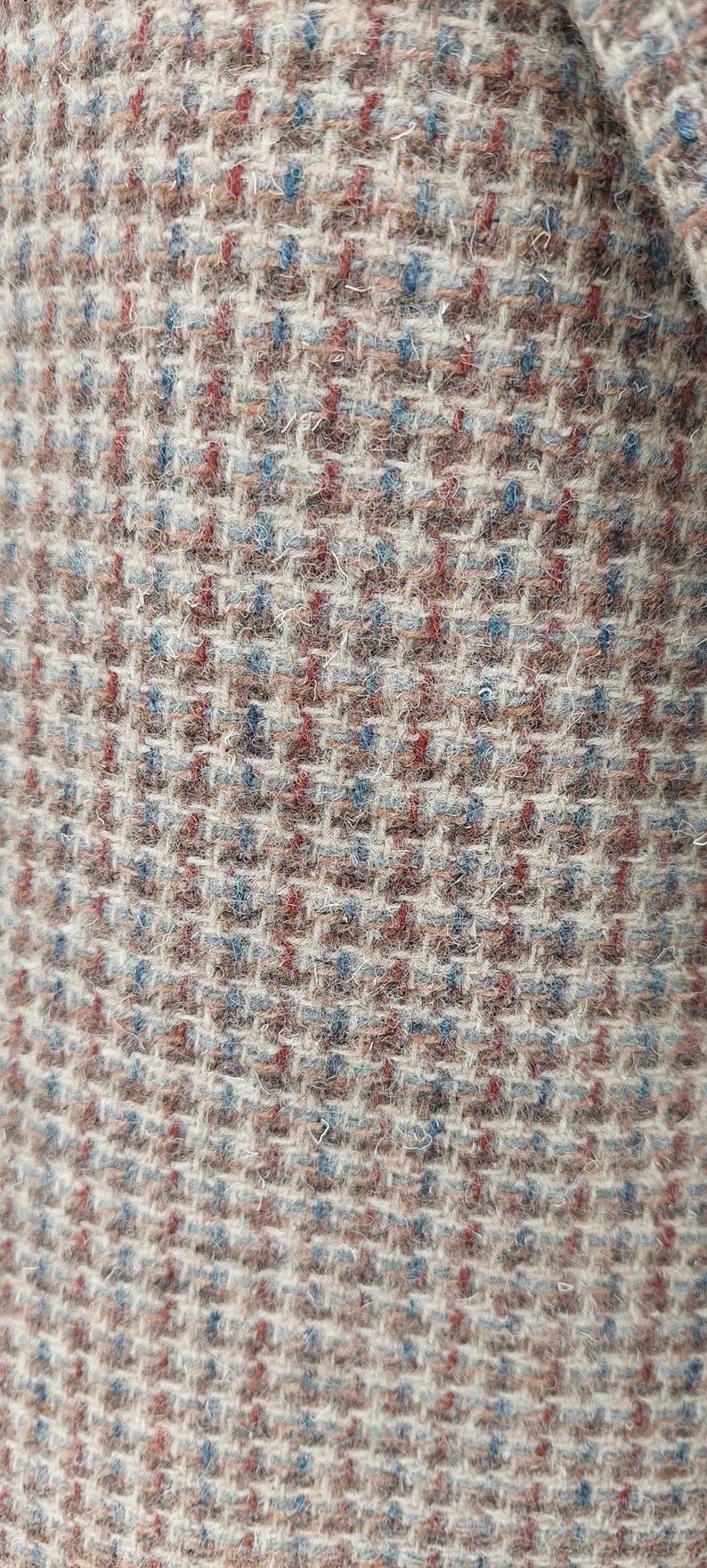 Peut inclure: Gros plan sur un tissu textur&eacute; avec un motif tiss&eacute;. Le tissu pr&eacute;sente un m&eacute;lange de couleurs, dont le beige, le marron, le rouge et le bleu, cr&eacute;ant un design subtil mais complexe. Le tissage est serr&eacute; et semble &ecirc;tre un mat&eacute;riau durable.