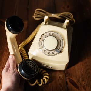 Stationäres Festnetztelefon in Cremefarbe. Altes Vintage-Telefon mit Wählscheibe.