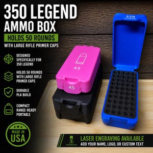 May include: Three ammo boxes: a black one, a pink one with a bullet graphic and the number 45, and a blue one. The pink box is stacked on the black box. The blue box is open, revealing a foam insert. Text on the boxes reads "350 LEGEND".