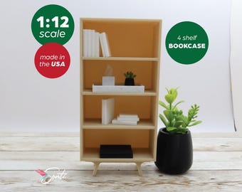 May include: A miniature 1:12 scale, 4-shelf bookcase made in the USA. The light wood bookcase is filled with white books and decorative items. A black pot with a green plant sits to the right of the bookcase.