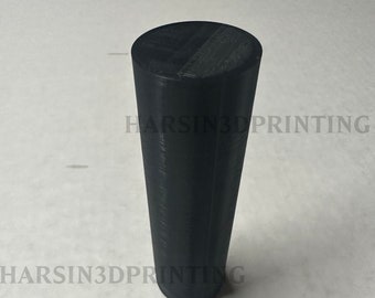 Puede incluir: Objeto cilíndrico negro con una parte superior plana y un cuerpo ligeramente cónico. El objeto tiene un acabado mate y parece estar hecho de un material sólido. El texto "HARSIN '84/89" está impreso en el objeto.