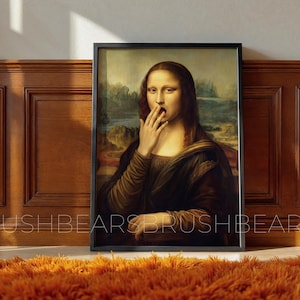 Könnte beinhalten: Gerahmter Druck der Mona Lisa mit einer Hand vor dem Mund. Das Kunstwerk ist vor einem Landschaftshintergrund platziert und schwarz gerahmt. Der Druck wird an einer Holzwand über einem orangefarbenen Shag-Teppich ausgestellt.