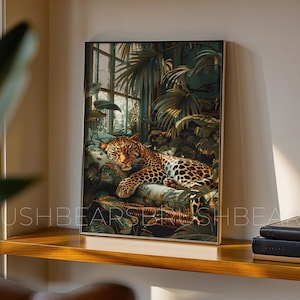 Puede incluir: Impresión artística enmarcada que muestra un leopardo descansando en medio de un exuberante follaje verde. El leopardo tiene un pelaje manchado y está acostado sobre un cojín estampado. El fondo incluye una ventana y más vegetación.