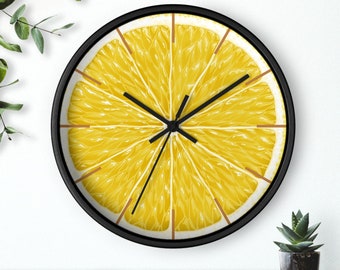 May include: A black framed clock with a yellow lemon slice design. The clock face has black hands and a black center.