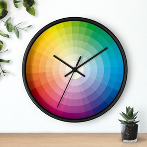 May include: A colorful clock with a rainbow color wheel design. The clock has black hands and a black frame.
