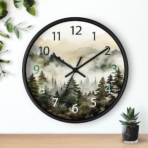 May include: A black framed wall clock with a watercolor design of a foggy forest scene. The clock face has Roman numerals and green hour and minute hands.