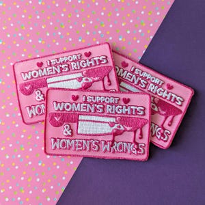 Könnte beinhalten: Drei rosa Bügelbilder mit weißen Stickereien. Die Patches lauten "Ich unterstütze Frauenrechte und Frauenfehler".
