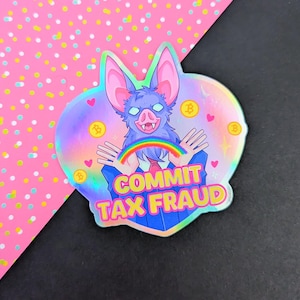 May include: A holographic sticker featuring a purple bat-like creature with a pig nose, wearing a blue suit and tie. The creature holds a small rainbow between its hands. The text COMMIT TAX FRAUD is printed in yellow with a pink outline below.