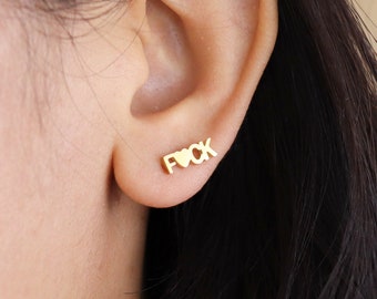 May include: Gold-tone stud earrings with the word "F**K" spelled out with a heart in place of the "O".
