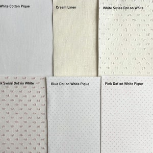 May include: Six fabric swatches in different colors and patterns. The swatches are labeled: White Cotton Pique, Cream Linen, White Swiss Dot on White, Pink Swiss Dot on White, Blue Dot on White Pique, and Pink Dot on White Pique.