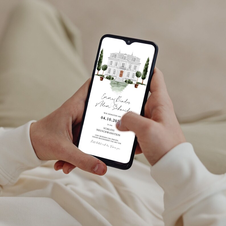 May include: A smartphone displaying a wedding invitation with a watercolor illustration of a castle. The invitation reads "Emma Binder & Alwin Schmidt" and "Wir heiraten am 04.10.2021 in Schloss Neuschwanstein".