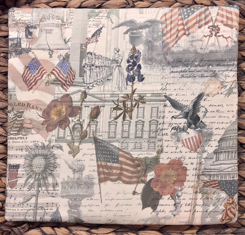 K&ouml;nnte beinhalten: Ein quadratischer Stoffuntersetzer mit einer Collage aus historischen amerikanischen Motiven, darunter die Liberty Bell, das Wei&szlig;e Haus, das Kapitol, amerikanische Flaggen, Wei&szlig;kopfseeadler, Blumen und kursiver Text.