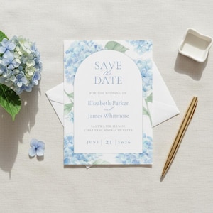 May include: A wedding invitation with a floral design featuring blue hydrangeas. The invitation reads "Save the Date" and includes the names Elizabeth Parker and James Whitmore, along with the wedding date and location.